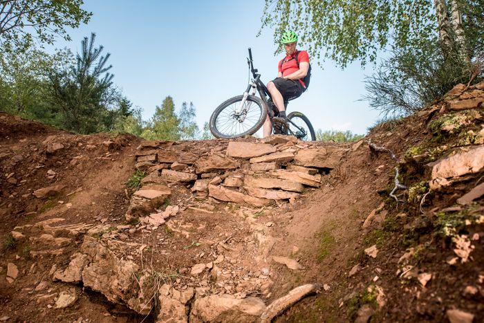 Ein Mountainbiker blickt einen steilen Hang herunter