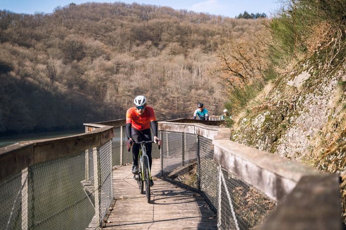Cyclistes gravel roulant sur la promenade de l’Ourdall près de Vianden, dans l’Éislek, au Luxembourg.