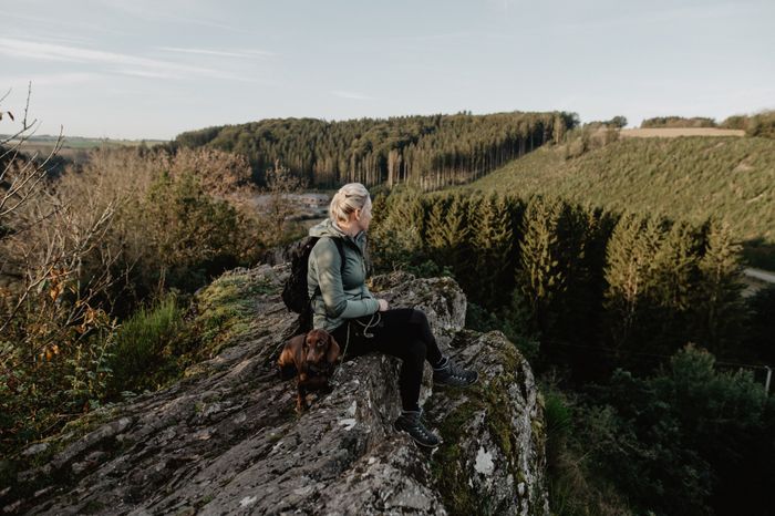 Woman enjoying the panoramic view from the Sideschlee viewpoint in Troisvierges on the Escapardenne Éislek Trail, Luxembourg.